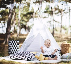 barn i tipitält i skogen sitter på matta