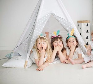 barn i tipitält och vit stol